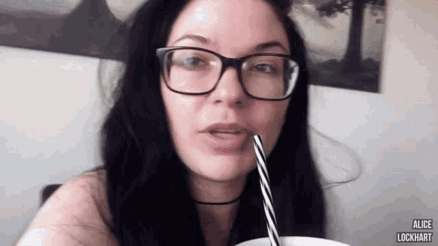 a woman wearing glasses is drinking through a straw and the name alice is on the bottom