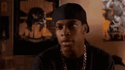a man wearing a bandana and a hat is sitting in front of a poster that says `` i don 't ''