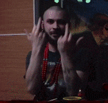 a man with a tattoo on his arm is making a devil horns sign
