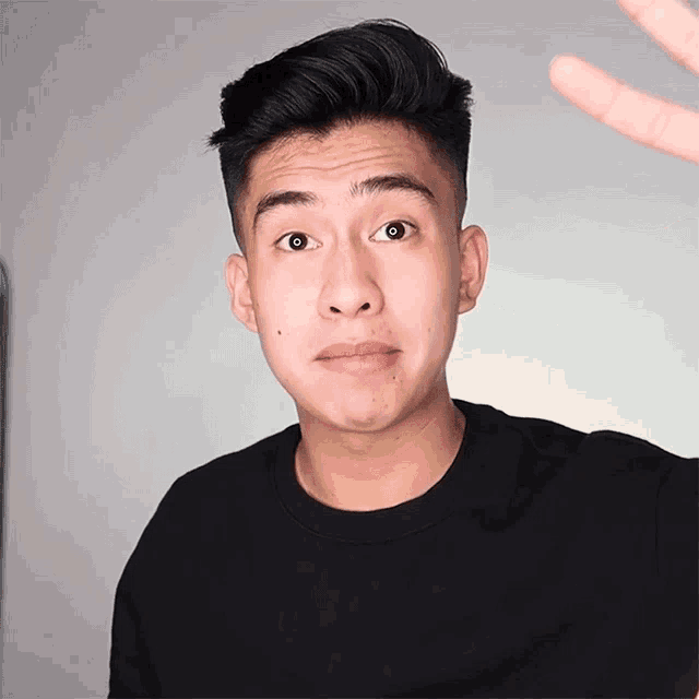 a young man wearing a black shirt with the word supreme on the front