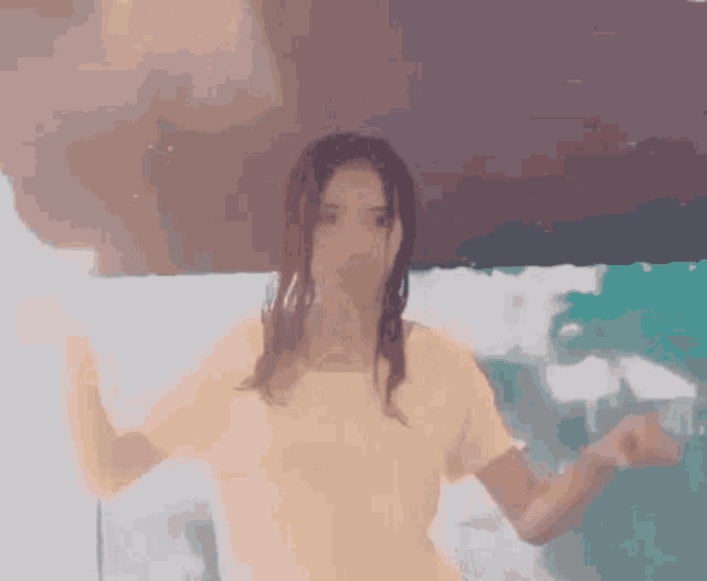 a woman in a yellow shirt is standing in the rain with her arms outstretched