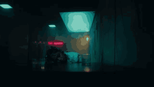 a person is laying on the floor in a dark room with a red sign that says digitally