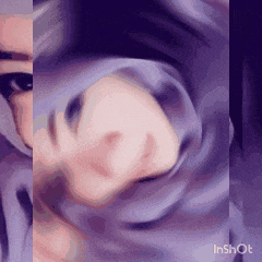 a close up of a woman wearing a purple hijab and sunglasses