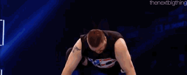two men are wrestling in a wrestling ring .