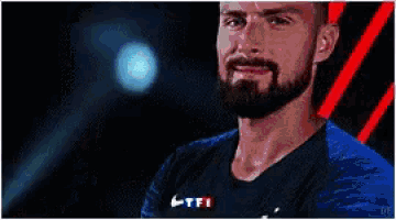 a man with a beard is wearing a blue nike shirt