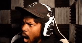 a man wearing a hat and headphones is making a face .