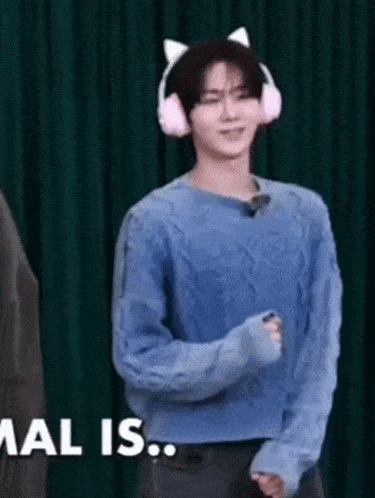 a young man wearing headphones and a blue sweater is dancing .