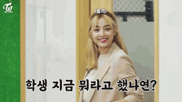 a woman in a suit is standing in front of a door and smiling .