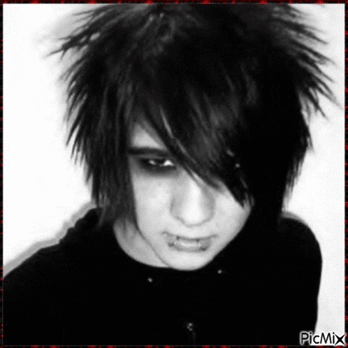 a black and white photo of a young boy with piercings in his mouth .
