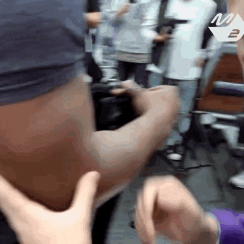 a blurry picture of a person 's arm with the letter m on the bottom right
