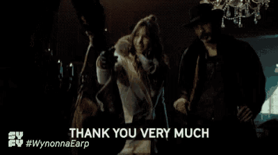 a man and a woman are standing next to each other in a dark room and the woman is saying thank you very much .