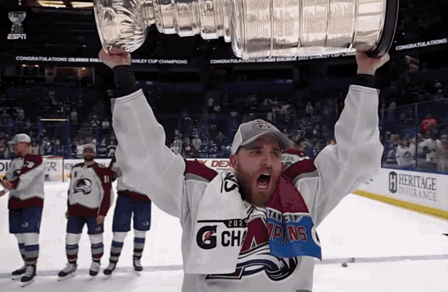a man holding up a trophy that says heritage insurance
