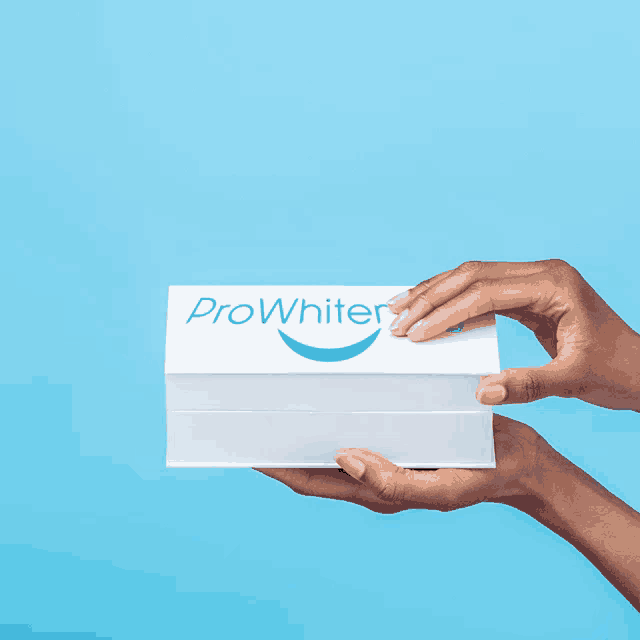 a person is holding a box of teeth whitening supplies in their hands
