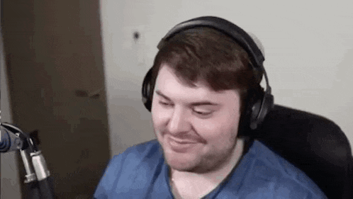 a man wearing headphones is sitting in front of a microphone .