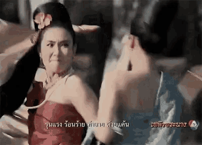 a woman in a red dress is fighting another woman in a blue dress in a foreign language .