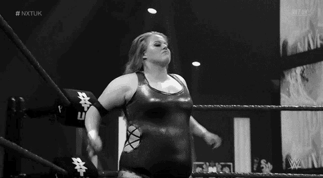 a black and white photo of a female wrestler in a wrestling ring .