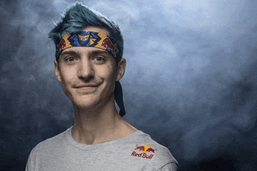 a young man with blue hair is wearing a red bull headband and smiling .