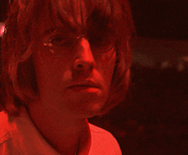 a close up of a man 's face with a red light behind him