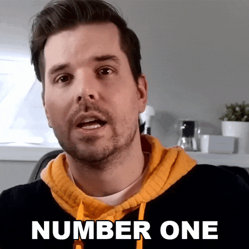 a man wearing a yellow hoodie says number one on the screen