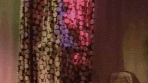 a blurred image of a curtain with a polka dot pattern and a purple light behind it .