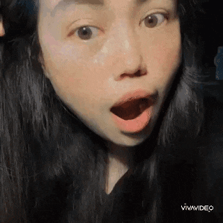 a close up of a woman 's face with her mouth open and a surprised look on her face .