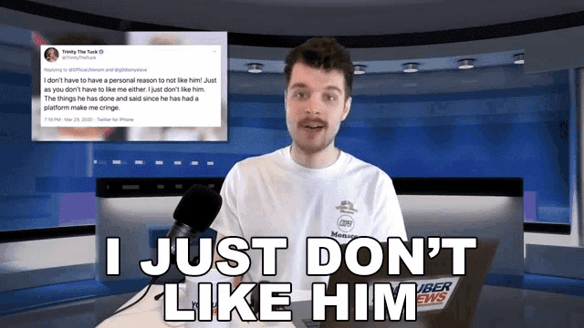 a man stands in front of a microphone with the words " i just don 't like him " above him