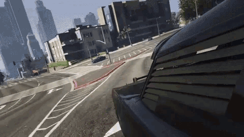 a car is driving down a street in a video game with buildings in the background