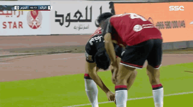 two soccer players on a field with ssc written on the bottom right