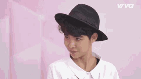 a young boy wearing a black hat and smiling .