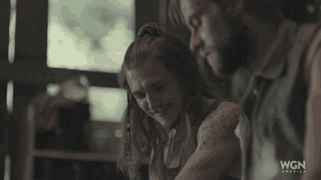 a man and woman are sitting next to each other with wgn america written on the bottom right