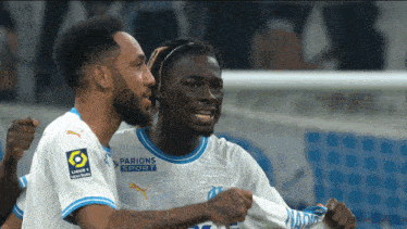 two soccer players wearing white jerseys with parions sport on the front
