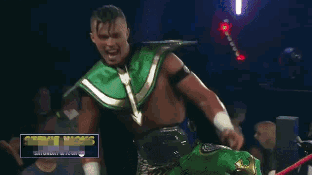 a wrestler is wearing a green and gold outfit and pointing at the camera