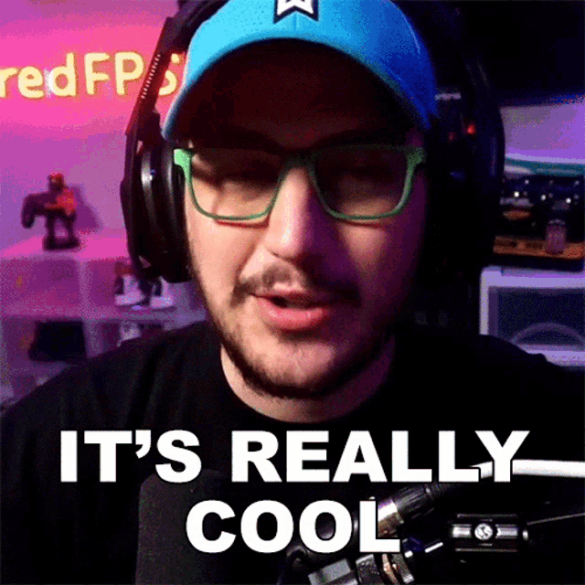 a man wearing headphones and glasses is saying it 's really cool