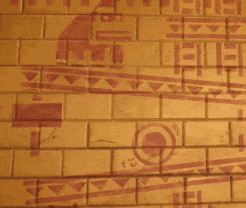 a man is standing in front of a brick wall with a drawing of a bird on it