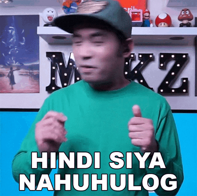 a man in a green shirt giving a thumbs up with the words hindi siya nahuhulog written below him