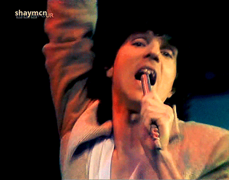 a close up of a person singing into a microphone with the words shaymcn written on the bottom