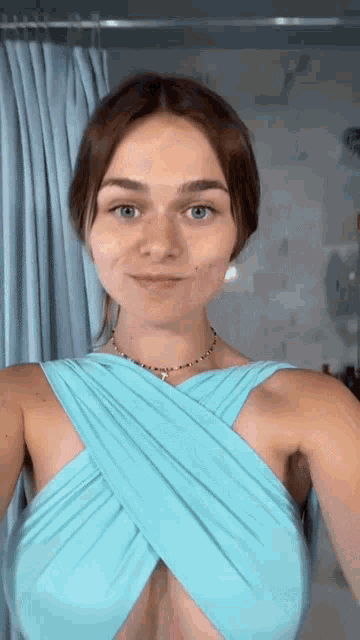 a woman is wearing a blue dress with a plunging neckline