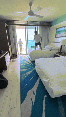 a hotel room with two beds and a sliding glass door