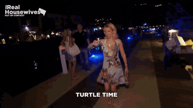 a woman walking down a sidewalk with the words turtle time written on the bottom