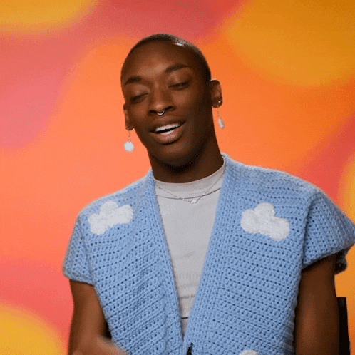 a young man wearing a blue sweater with white clouds on it
