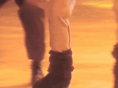 a person with a prosthetic leg is walking on a wooden floor in a blurry photo .
