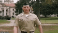 a man in a military uniform is standing in a field .