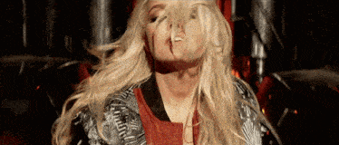 a woman with long blonde hair is making a face