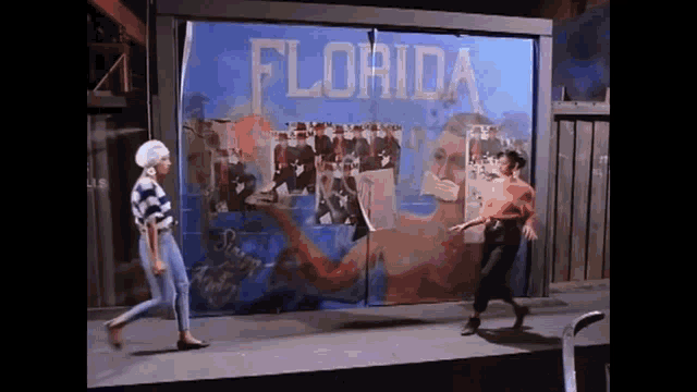 two women are dancing in front of a wall that says florida .