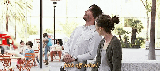 a man and a woman are standing next to each other and the man is saying " fuck off voice " .