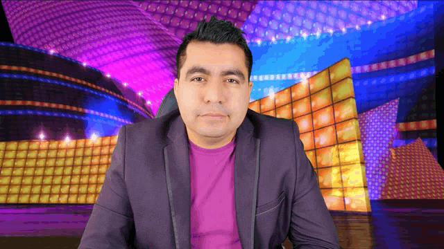 a man wearing a purple shirt and a purple jacket stands in front of a colorful background