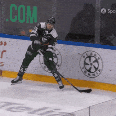 a hockey player on the ice in front of a .com sign