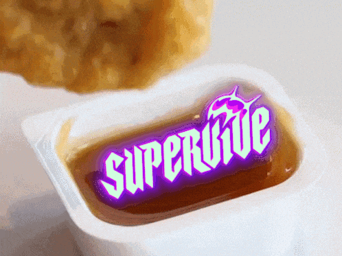 a packet of supervive sauce with a chicken nugget behind it