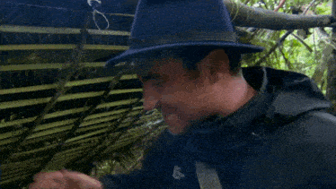 a man wearing a hat and a black jacket says that 's how you do it my son