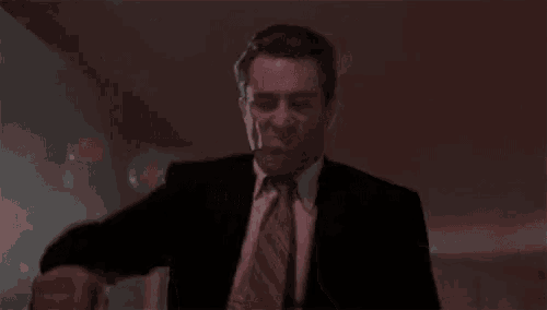 a man in a suit and tie is dancing .